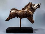 bronze statue of a dog on a marble base on a gray background