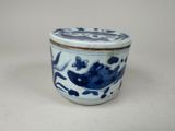 un petit pot bleu et blanc orné d'un motif d'oiseau