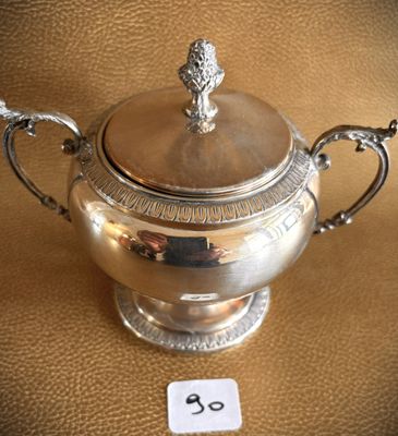 a silver teapot on a table with a price tag