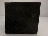 a close up of a black marble block on a table