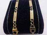 a close up of a pair of gold bracelets on a black velvet case