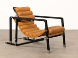 un fauteuil en cuir orange posé sur un sol en béton