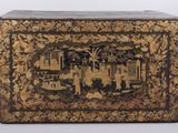an old black and gold box with a picture of people on it