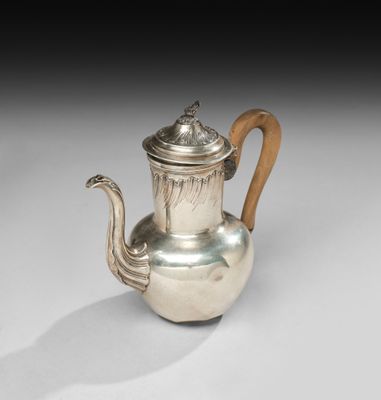 une théière ancienne en argent, dotée d'une poignée en bois, posée sur un support blanc