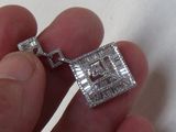 a person holding a silver and diamond necklace in their hand