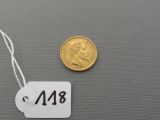 une petite pièce d'or à laquelle est attachée une étiquette indiquant son prix