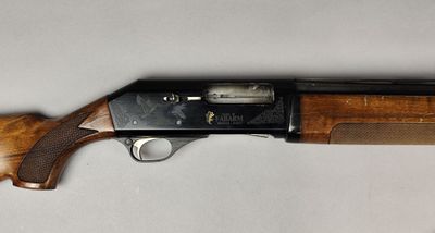 a close up of a shotgun with a wooden handle on a white surface