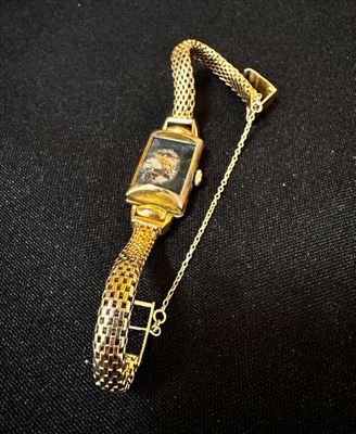 a close up of a watch on a chain on a black surface