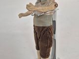 a close up of a doll on a stand on a white surface