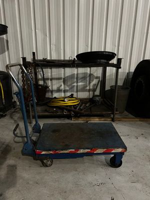 un chariot bleu muni d'une poignée bleue, posé dans un garage