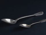 two spoons that are sitting next to each other on a table