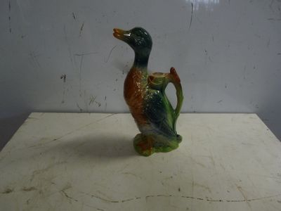 a small ceramic duck that is sitting on a table