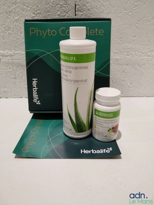 une bouteille d'Herbalife et une boîte de comprimés posées sur une table