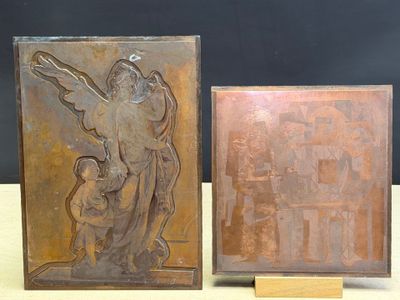 pair of bronze plaques of a woman and child on a table