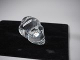 a crystal skull sitting on a black velvet surface