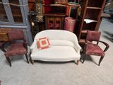 a white couch and chairs in a room with a bookcase