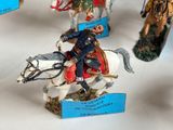 many figurines of men riding horses on display