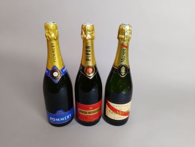 trois bouteilles de champagne posées côte à côte sur une table