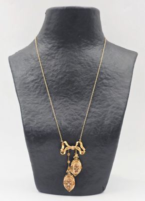 un collier en or orné d'un crâne et d'une croix, porté par un mannequin