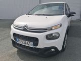 l'avant d'une Citroën blanche garée devant un immeuble