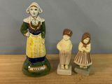 deux figurines représentant une femme et un enfant posées sur une table en bois