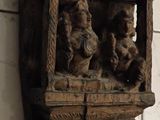 carvings on the wall of a bathroom with a toilet in the background