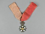 une image représentant une médaille ornée d'une étoile, suspendue à un ruban