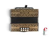 an old black and gold accordion sitting on top of a white surface