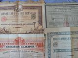 three old paper certificates sitting on top of a blue sheet