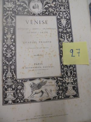 un vieux livre sur lequel est collé un autocollant jaune, posé sur une table