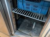 a blue basket in the open door of a stainless steel refrigerator