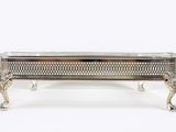 a silver plated box with a handle and legs on a white background