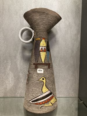 un vase orné d'un oiseau, exposé dans une vitrine
