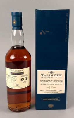 une bouteille de whisky posée sur une table à côté d'un coffret