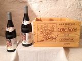 three bottles of wine in a wooden box on a table