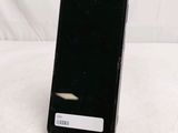 the back of a black cell phone sitting on top of a table