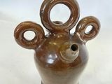 un vase marron orné d'une tête d'ours