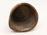 a brown vase that is sitting on a white surface
