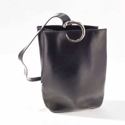 black leather bucket bag with metal ring handle on white background