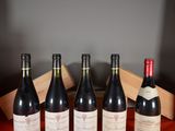 four bottles of wine are lined up in a row on a table