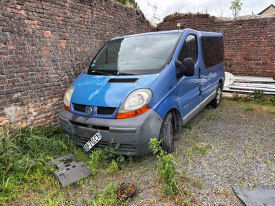 une camionnette bleue garée devant un mur de briques