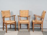 trois chaises en bois placées les unes à côté des autres sur un sol à carreaux