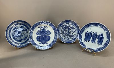 four blue and white plates with figures on them