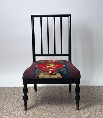 une chaise noire avec une assise rouge et bleue