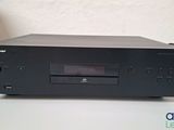a black cd player sitting on top of a table next to a box