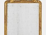 un miroir à cadre doré représentant des fleurs et des feuilles sur fond blanc