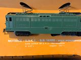a green train car sitting on top of a yellow box