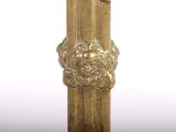 a close up of a gold clock on a wooden pole