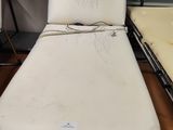 un lit blanc qui se trouve dans une chambre