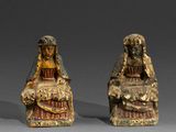 deux figurines représentant une femme et un homme assis l'un à côté de l'autre